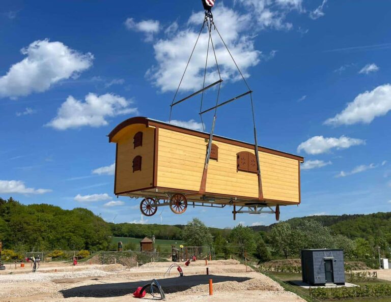 Zauberwagen hängt beim Aufstellen im Eifel Camp am Kran