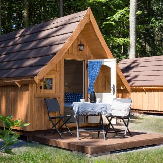 Ein kleines Campinghaus von NAWALO mit einladend geöffneter Tür.