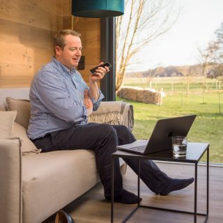 uniCube Mann mit Handy sitzt auf dem Sofa