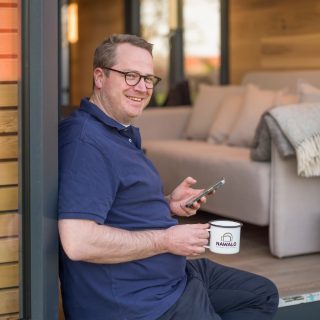 uniCube Mann mit Tasse sitzt an der Tür